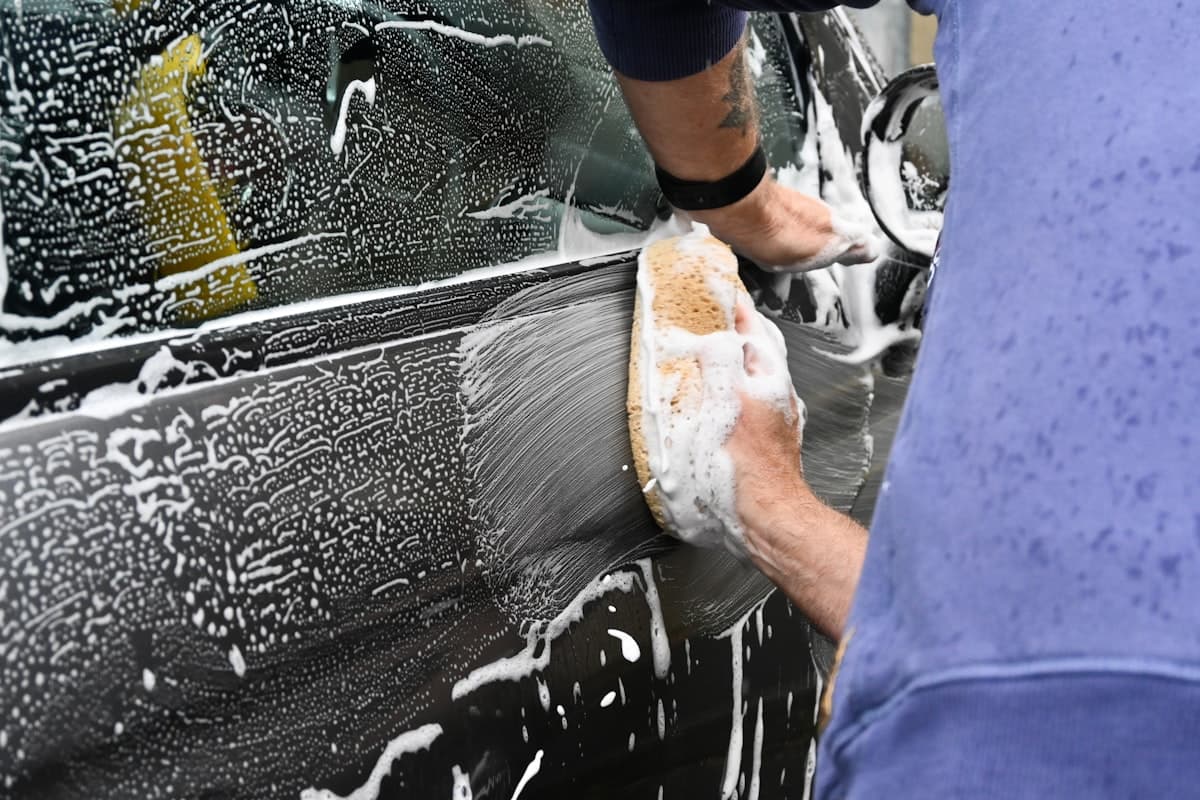 A mobile detailer washing a vehicle by hand
